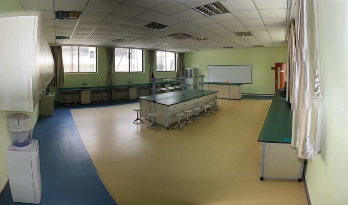 Empty laboratory room with workstations, benches, sinks, and testing surfaces
